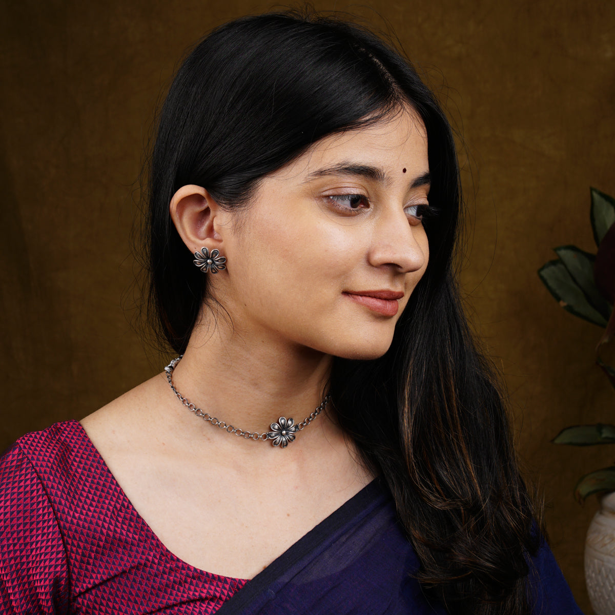 a woman wearing a necklace and earrings