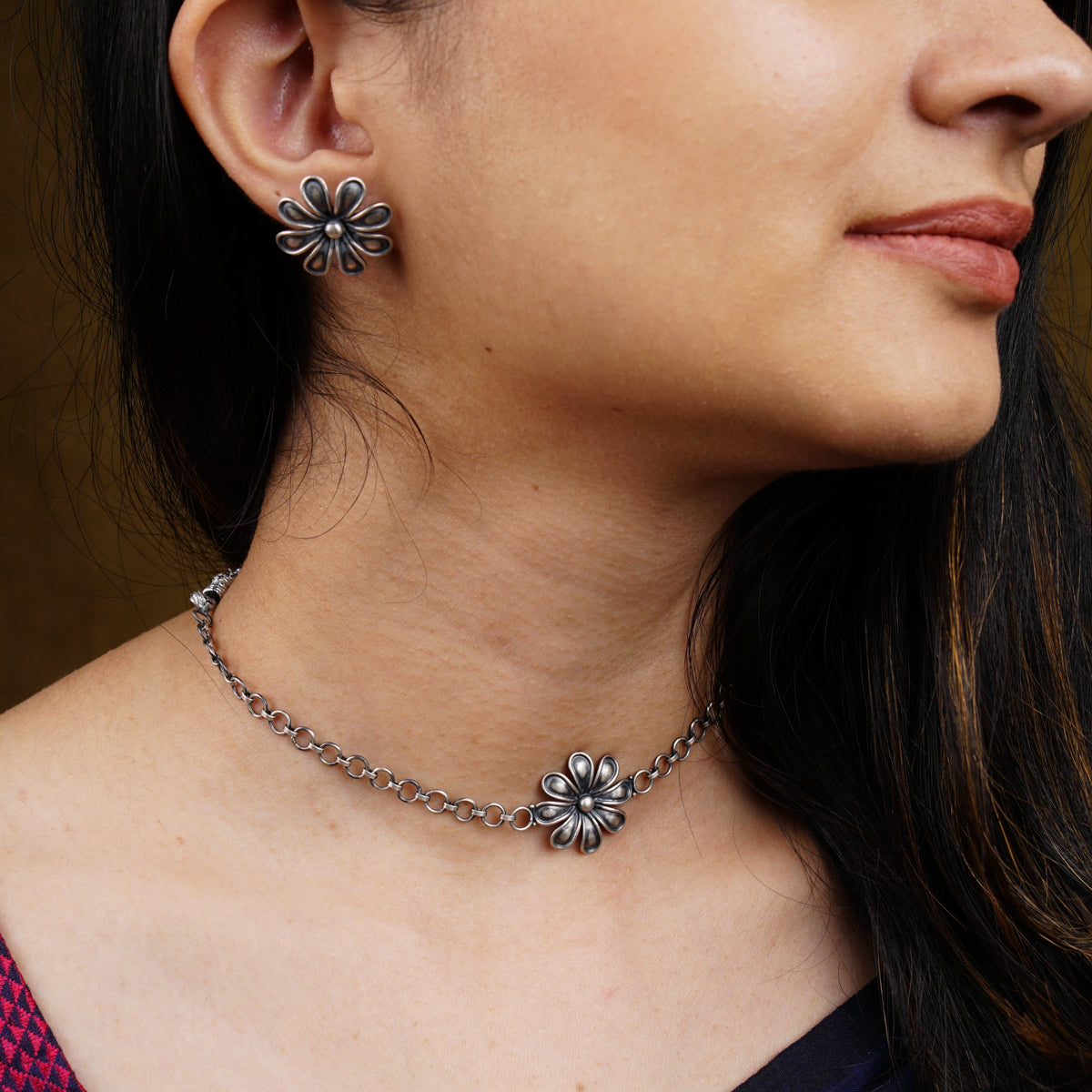 a close up of a woman wearing a necklace and earrings