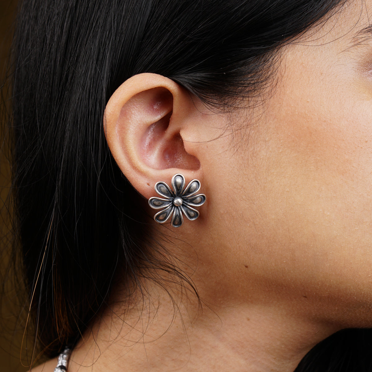 a close up of a person wearing a pair of earrings
