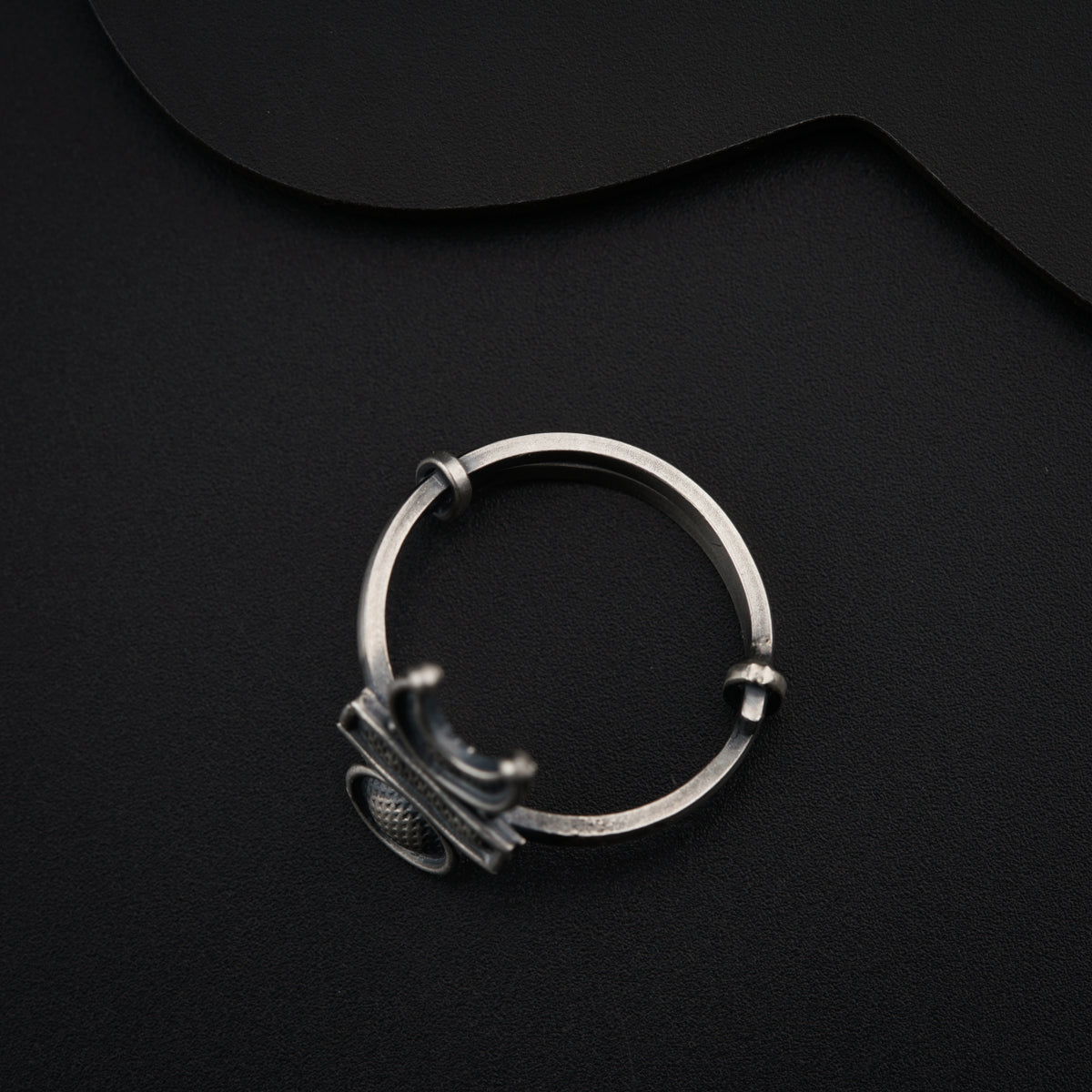 a metal ring with a handle on a black surface