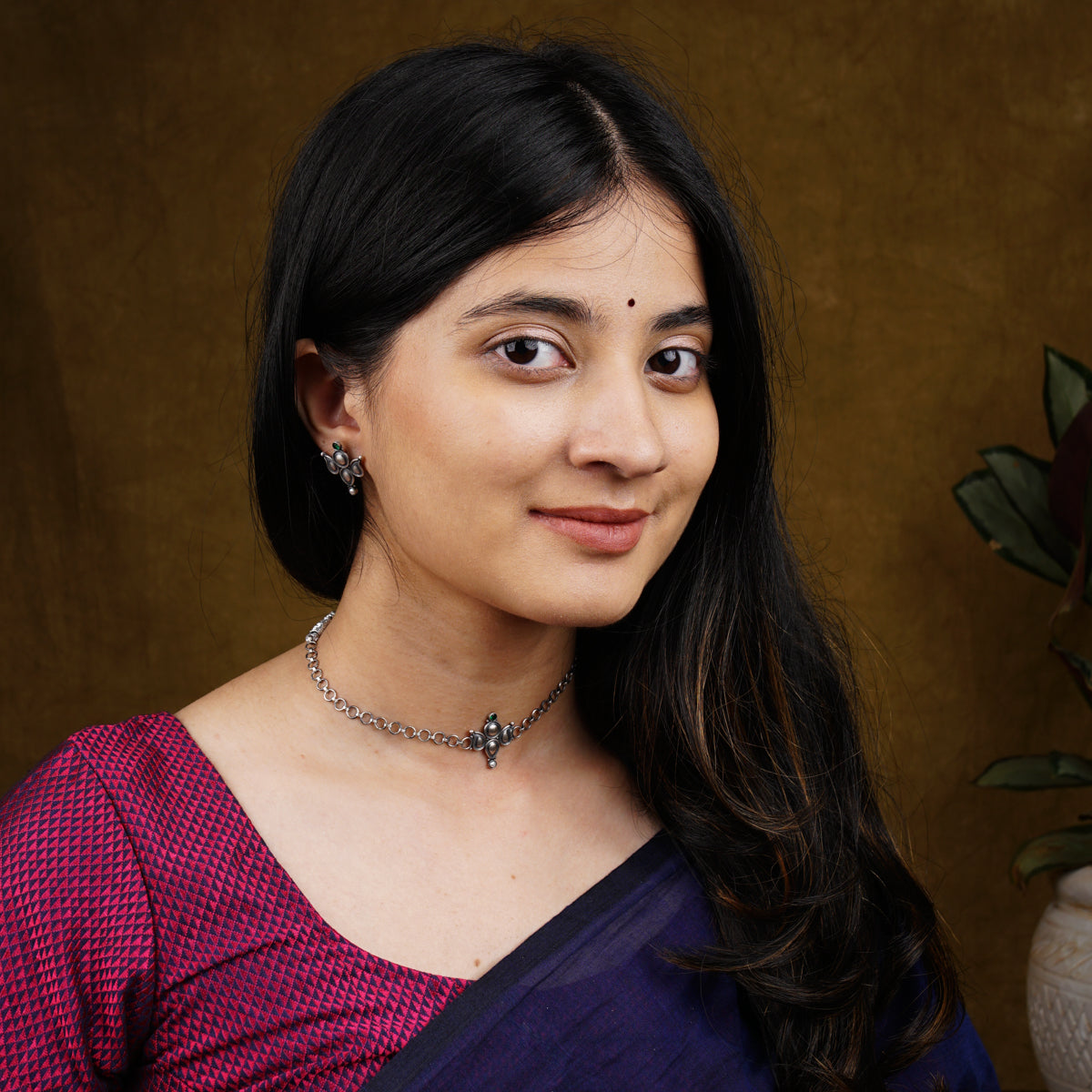 a woman wearing a purple sari and a necklace