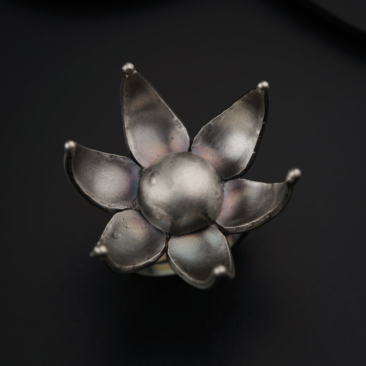 a silver flower brooch sitting on top of a table
