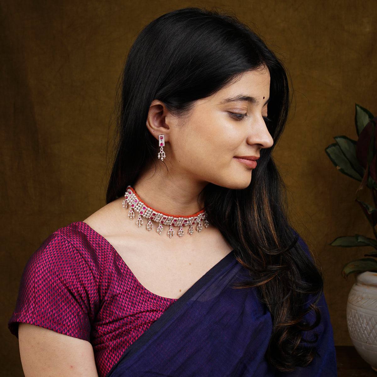 a woman wearing a purple saree and a necklace