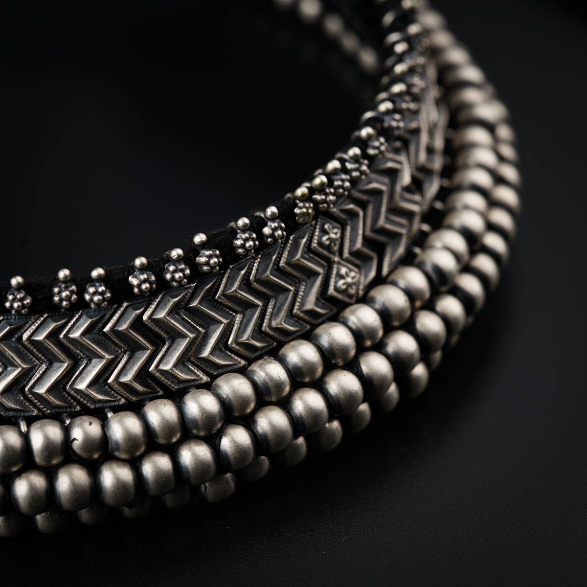 a close up of a necklace on a black surface