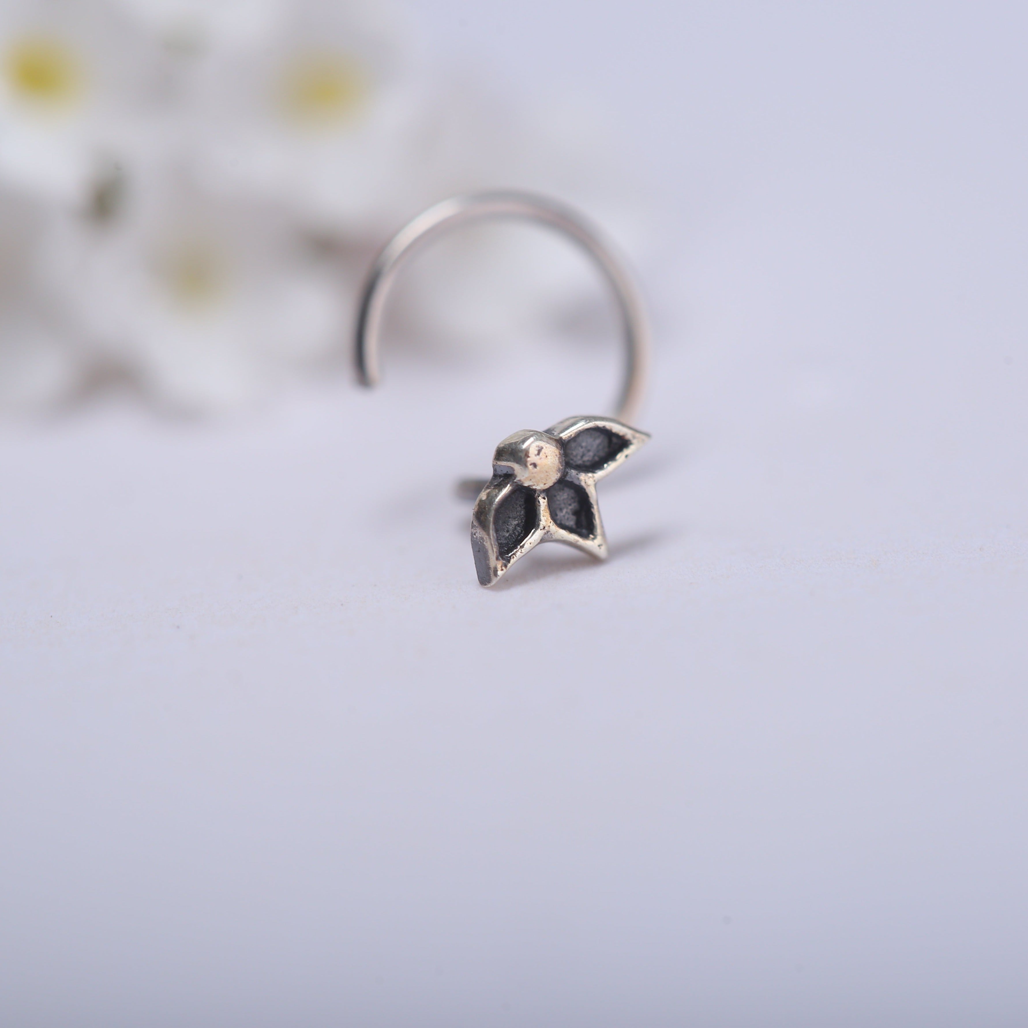 a close up of a ring with flowers in the background