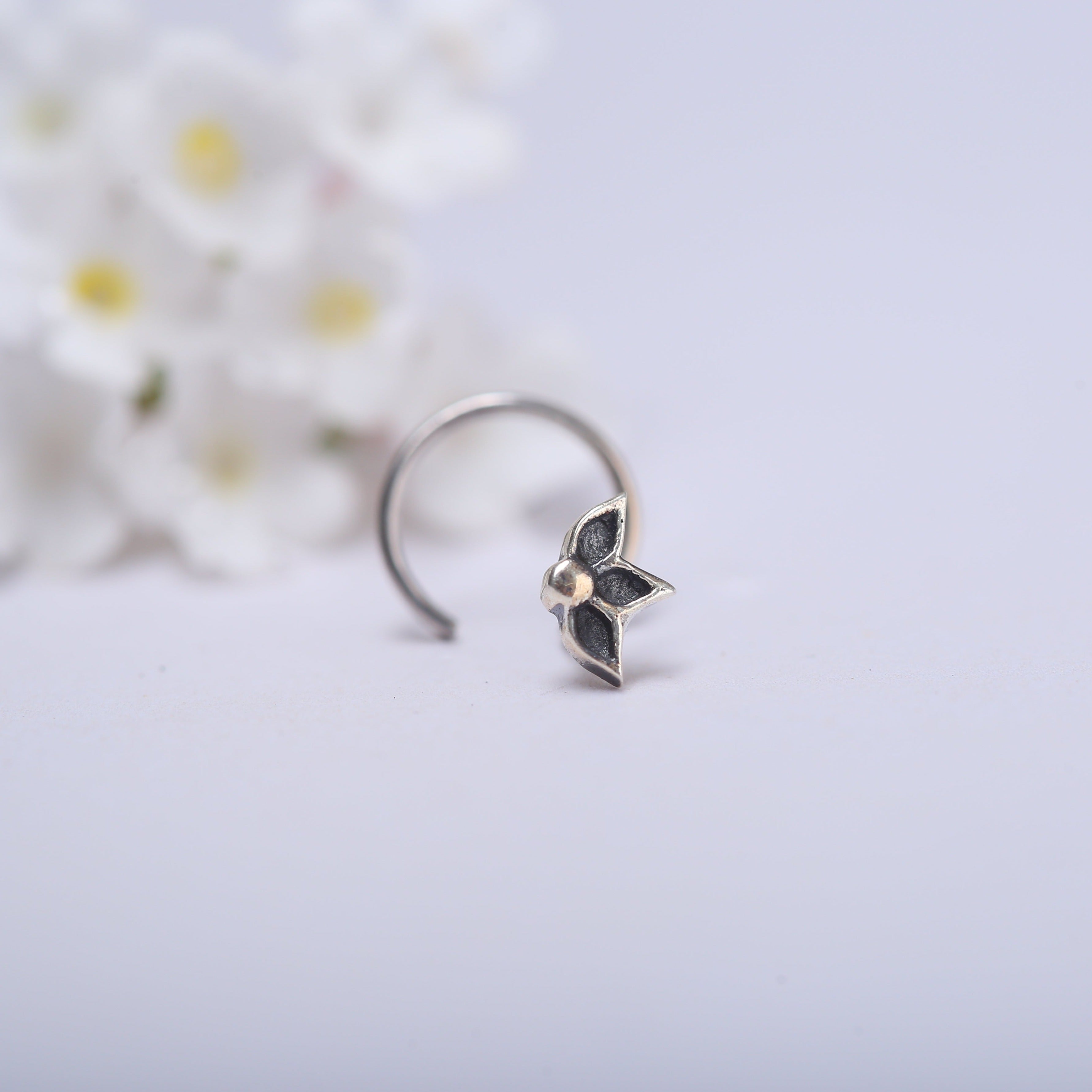 a close up of a ring with flowers in the background