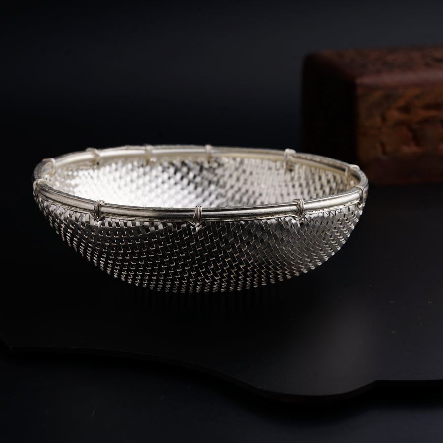 a silver bowl sitting on top of a black table