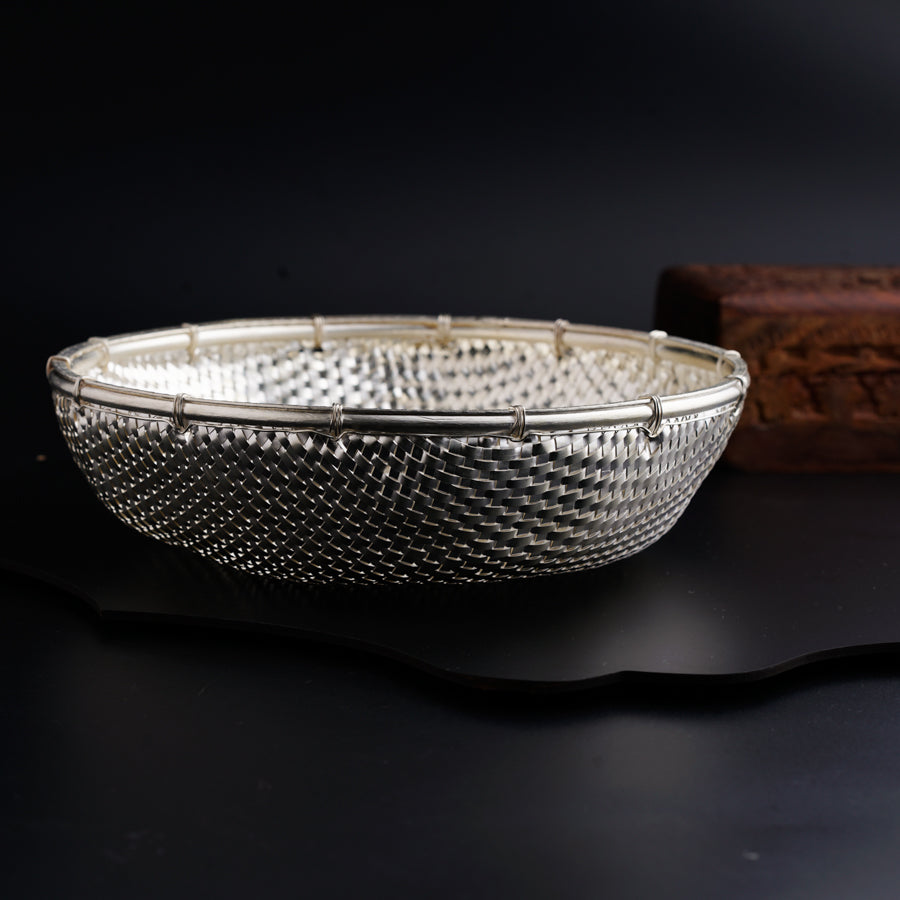 a silver bowl sitting on top of a black table