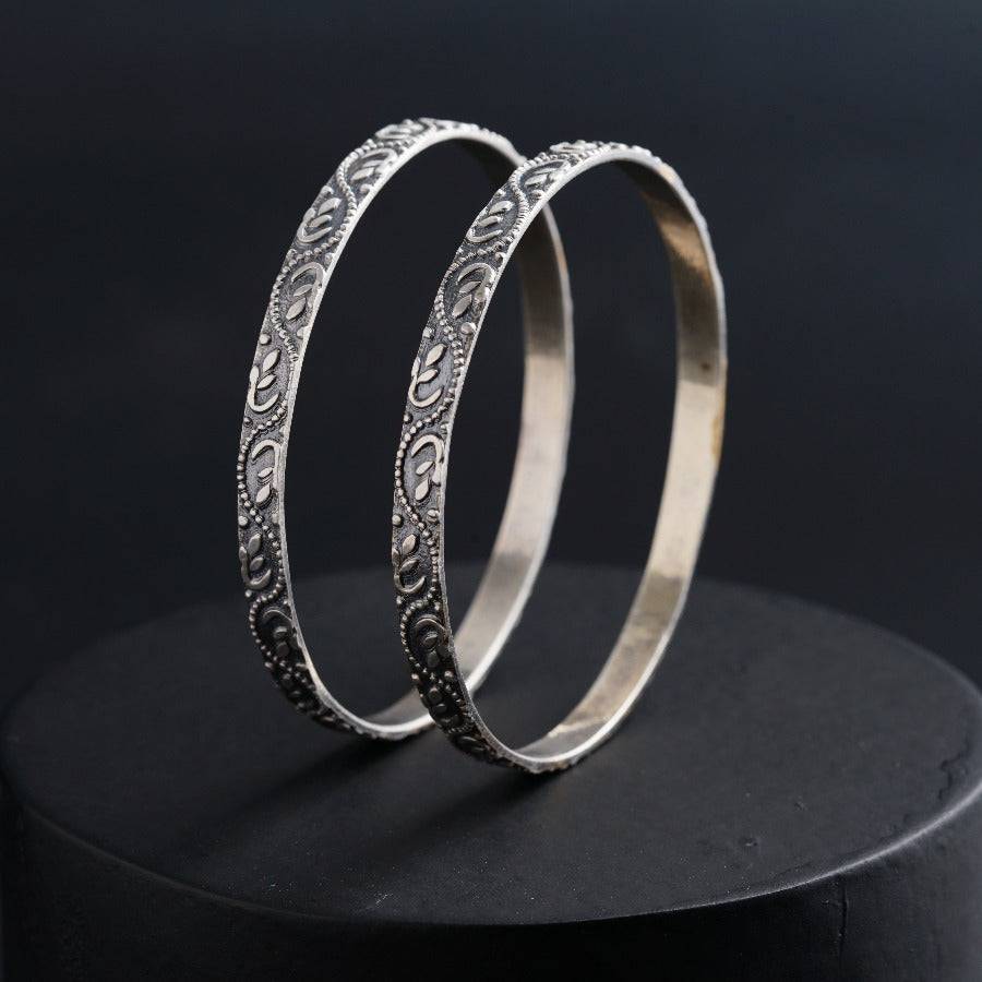 two silver rings sitting on top of a black surface