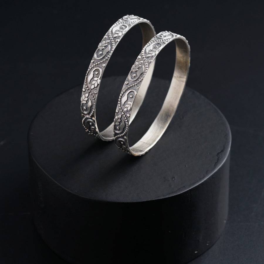 a pair of silver rings sitting on top of a black surface