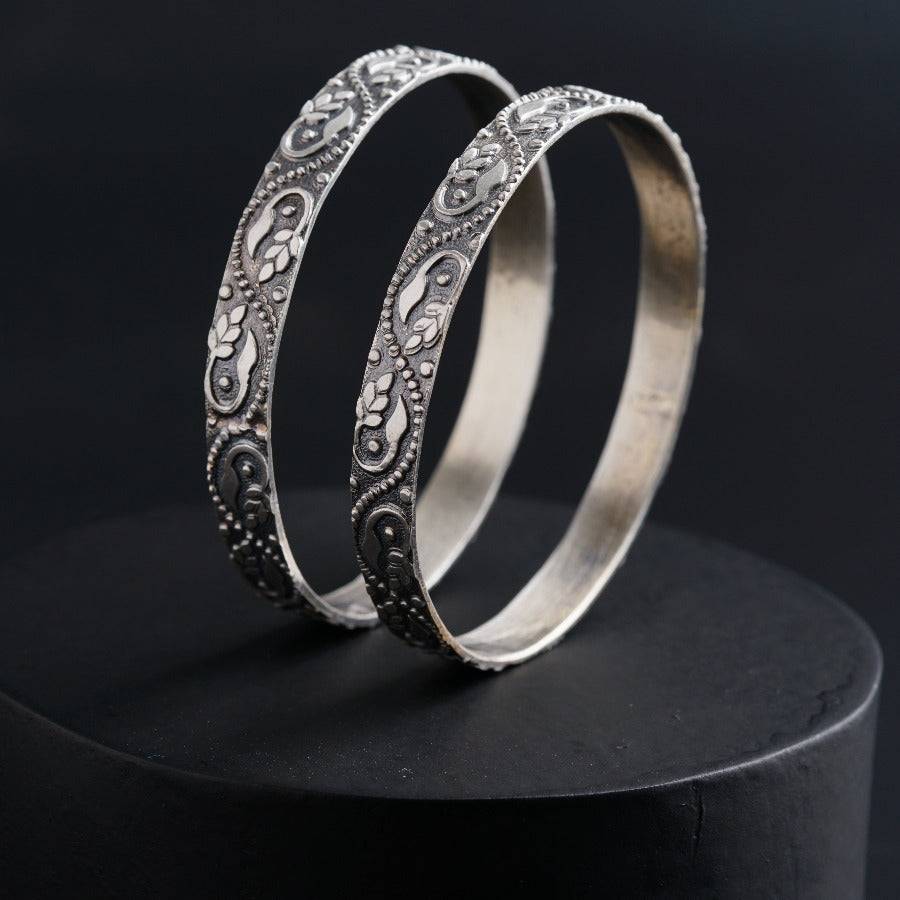 a pair of silver rings sitting on top of a black surface