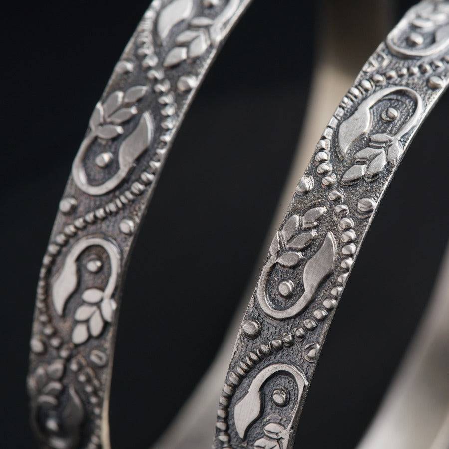 a close up of a pair of silver bracelets