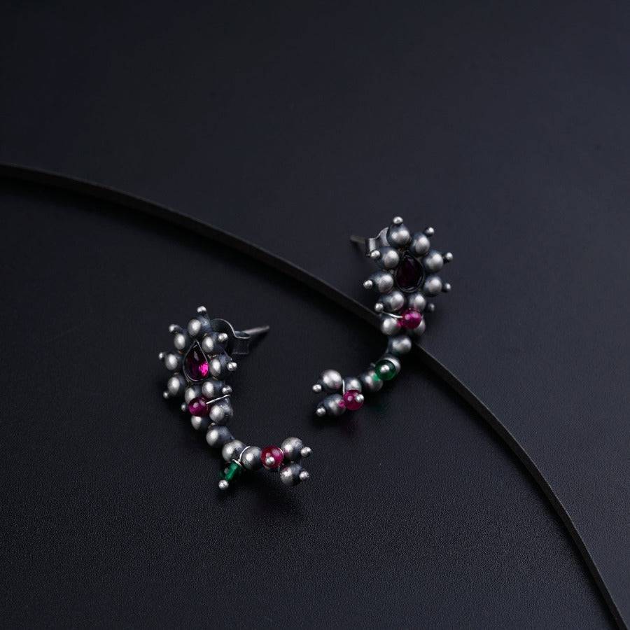 a close up of a pair of earrings on a black surface