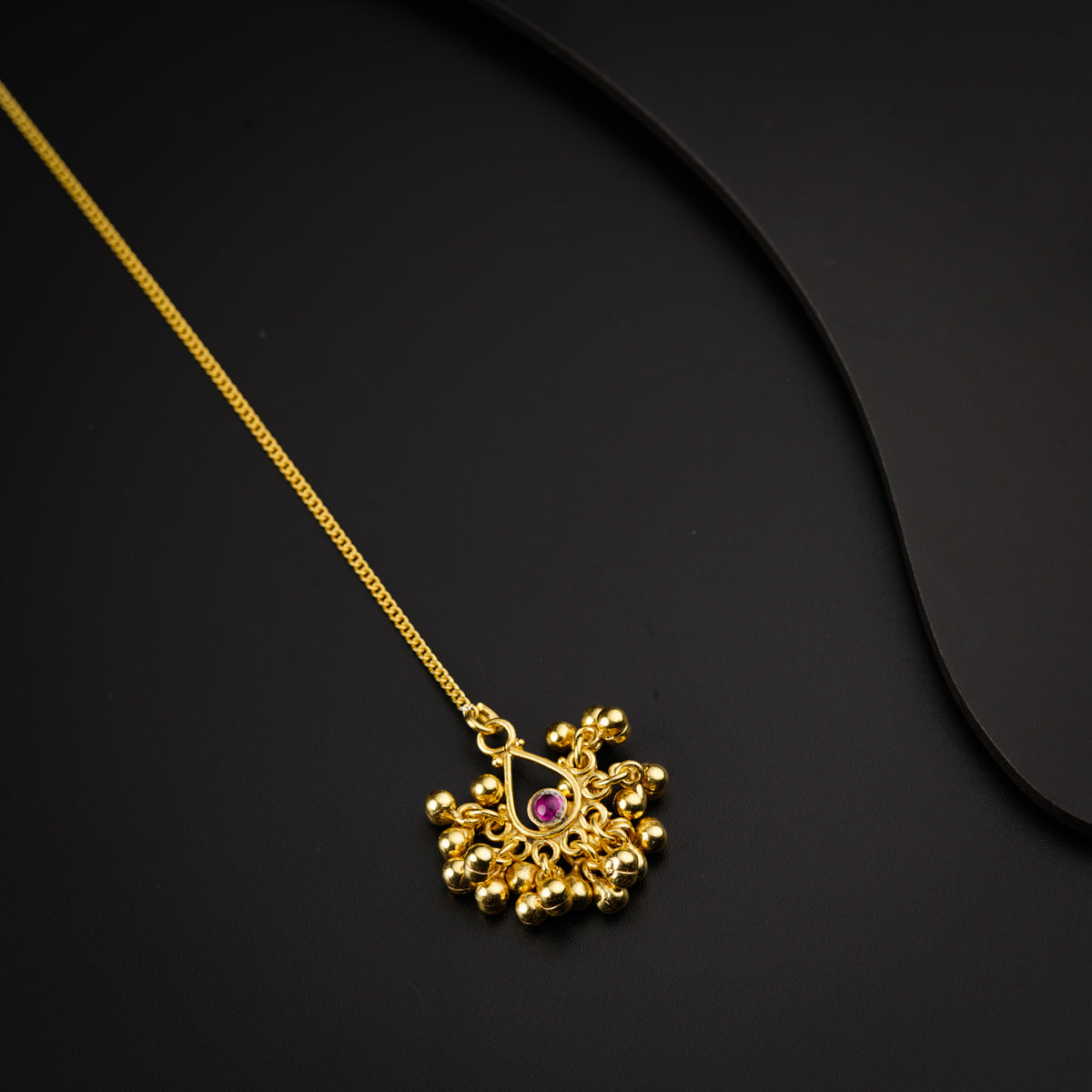 a gold necklace on a black surface