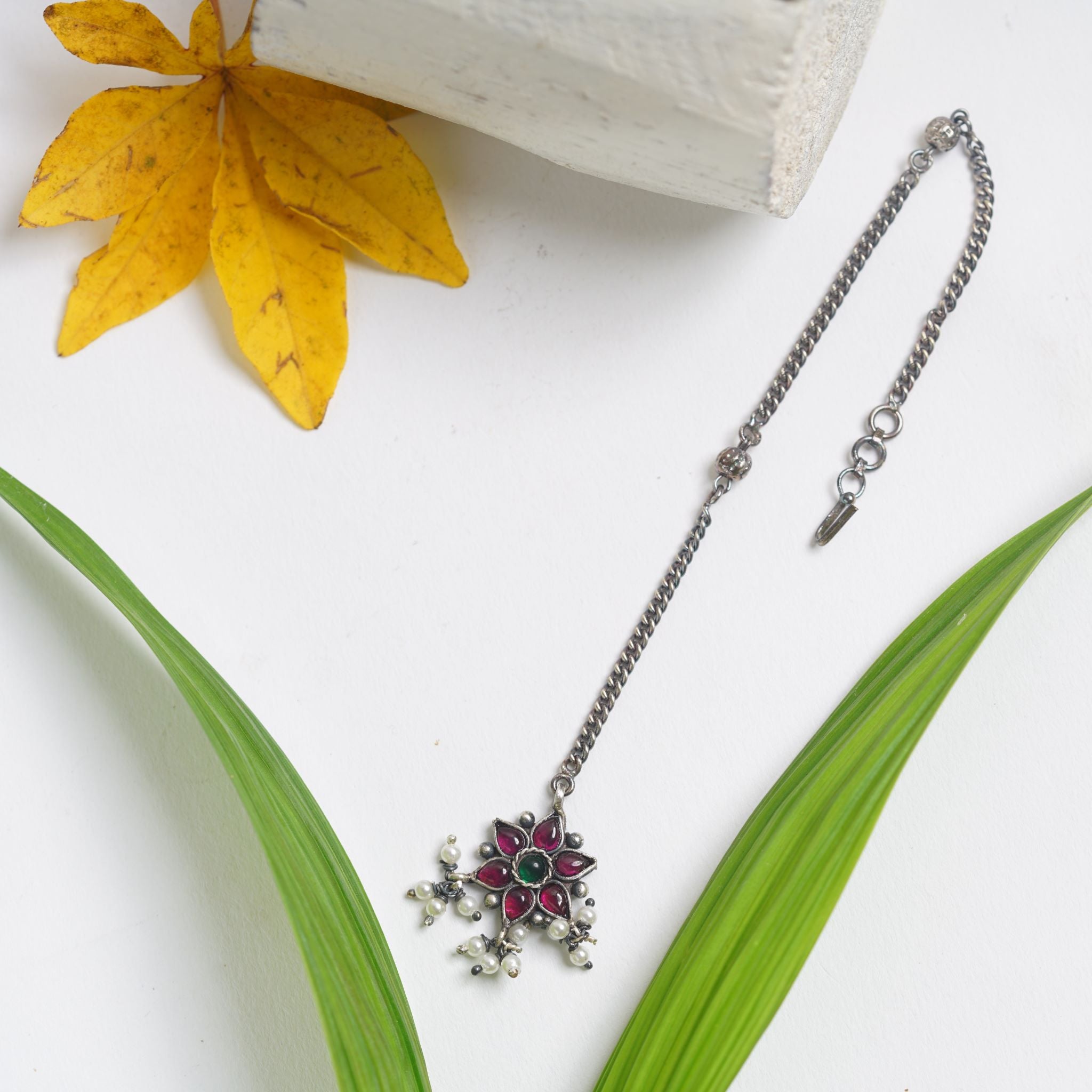 a necklace with a flower on a chain