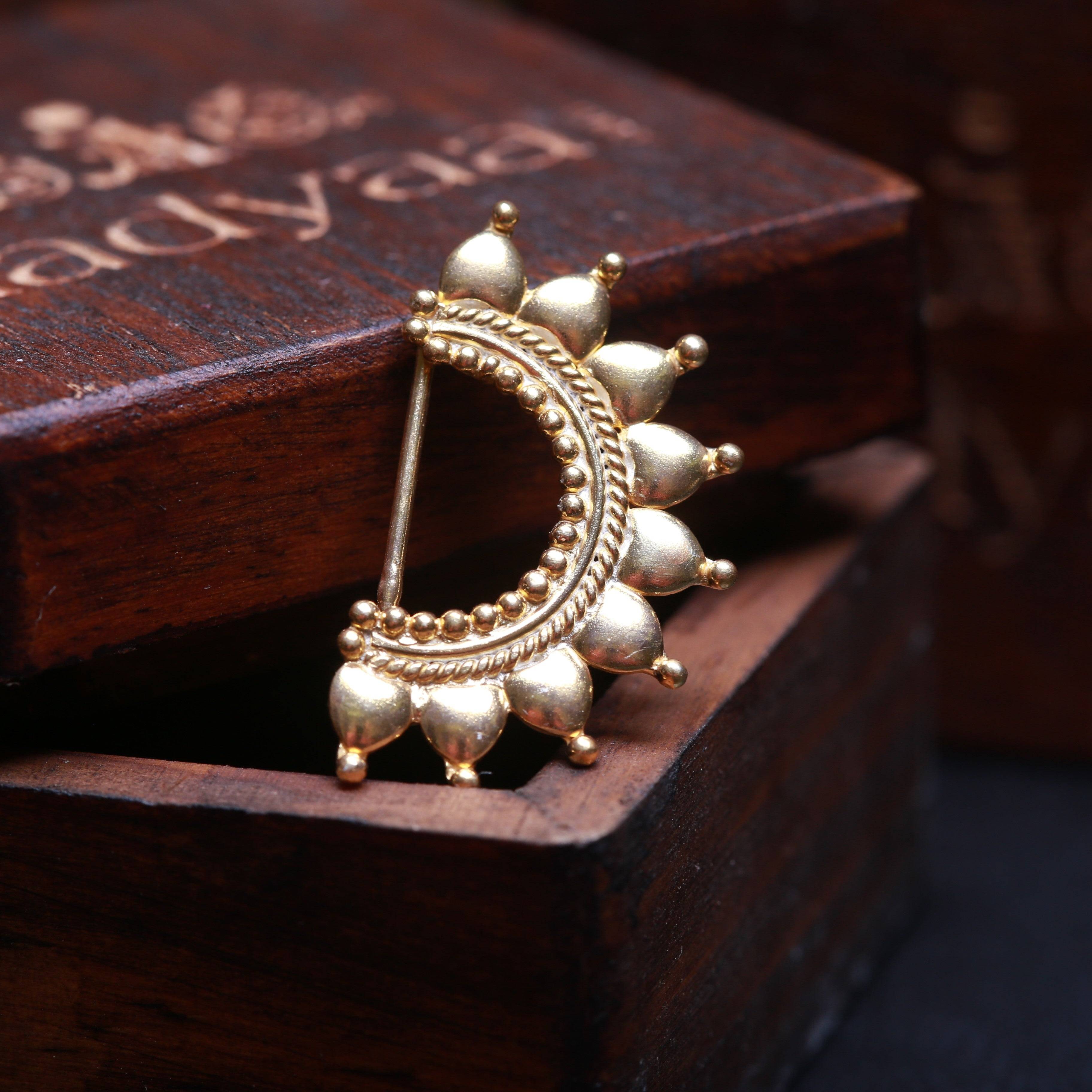 a close up of a pair of earrings on a wooden box