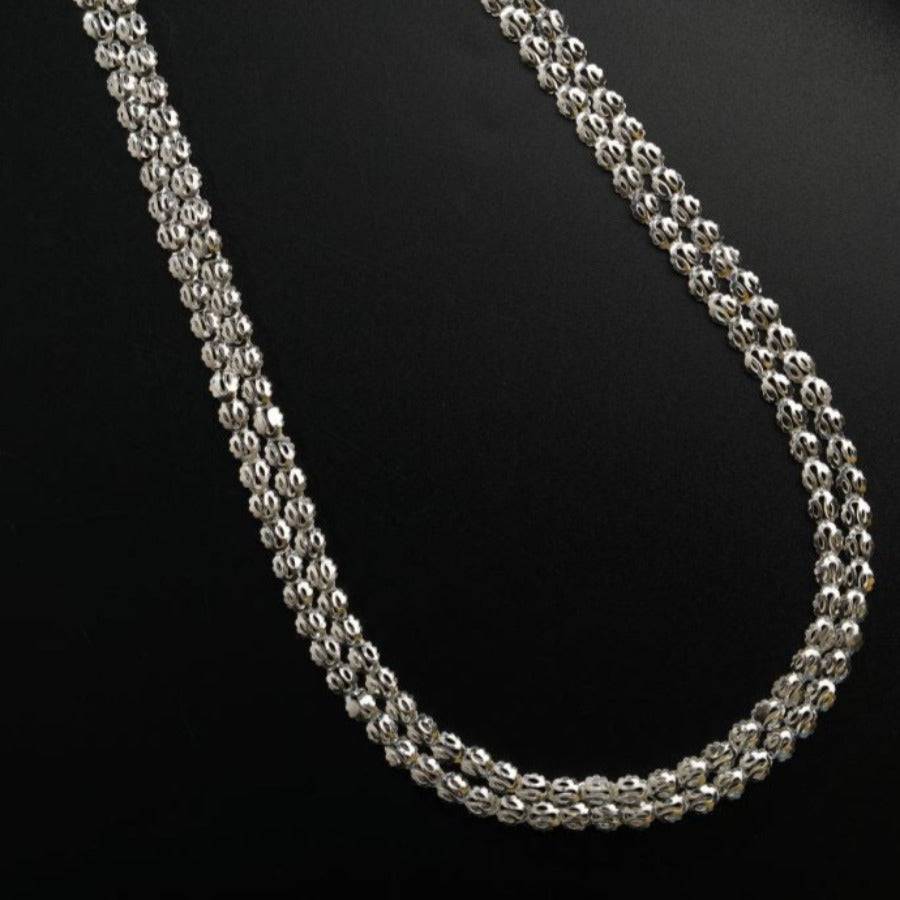 a silver chain on a black surface