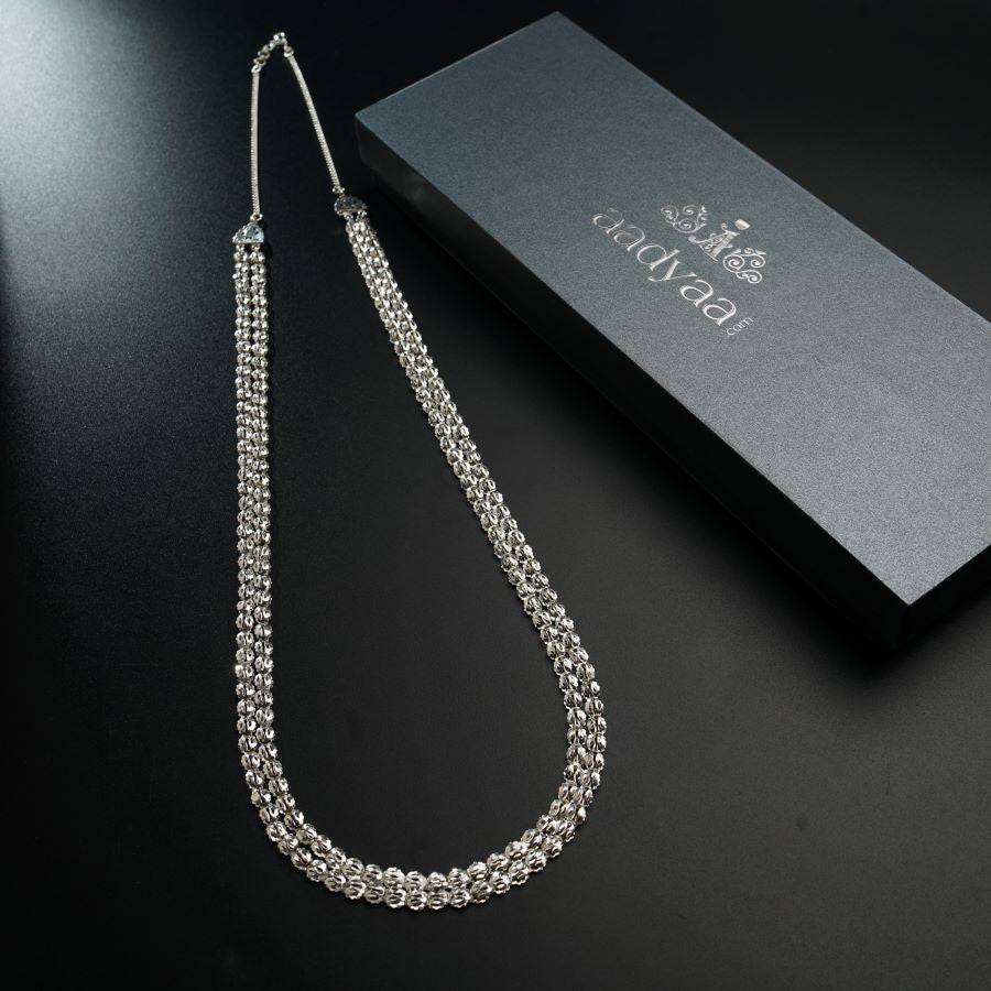 a long silver chain on a table next to a box