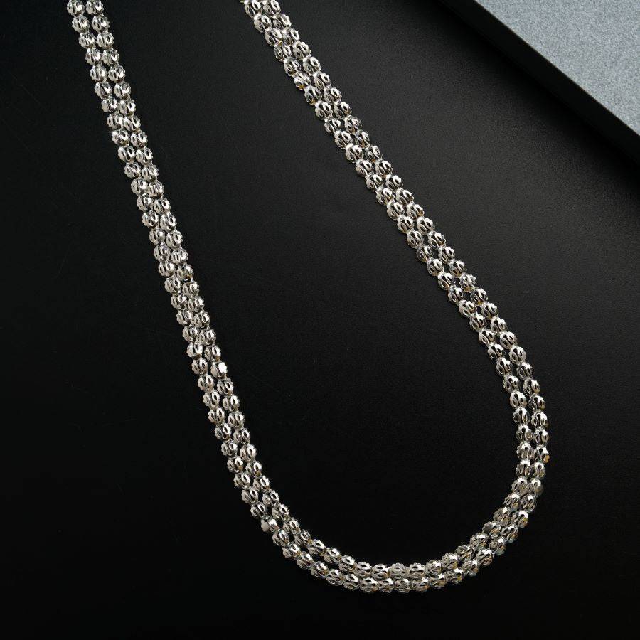 a silver chain on a black surface