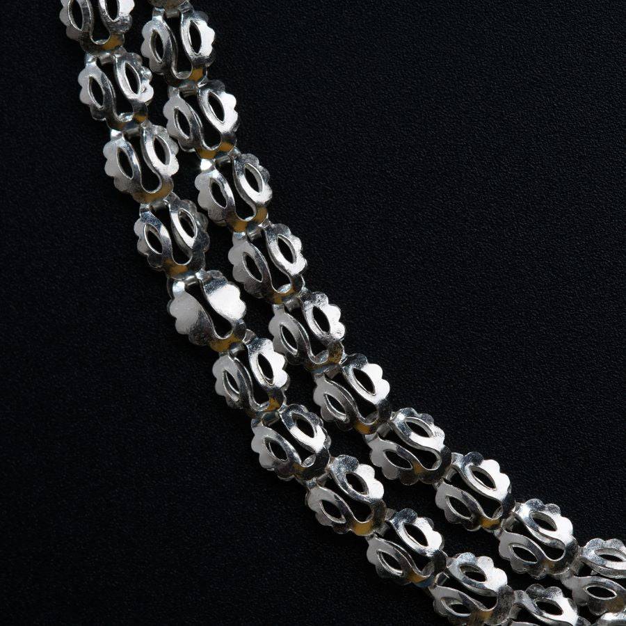 a close up of a necklace on a black surface