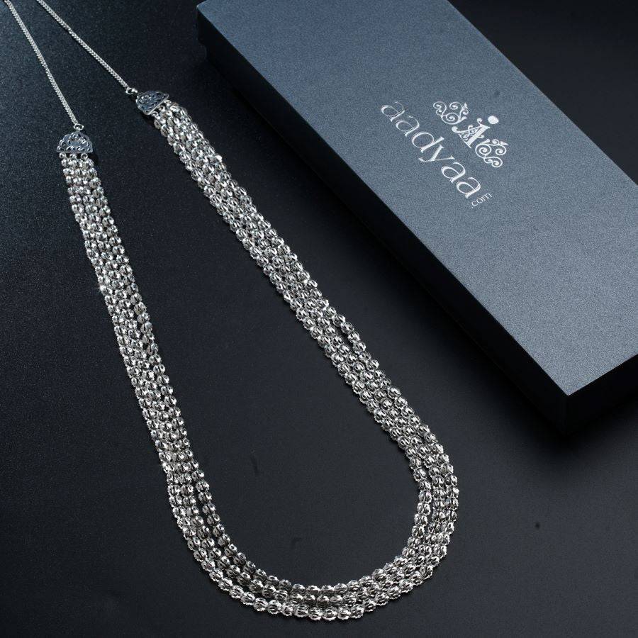 a silver necklace with a box on a table