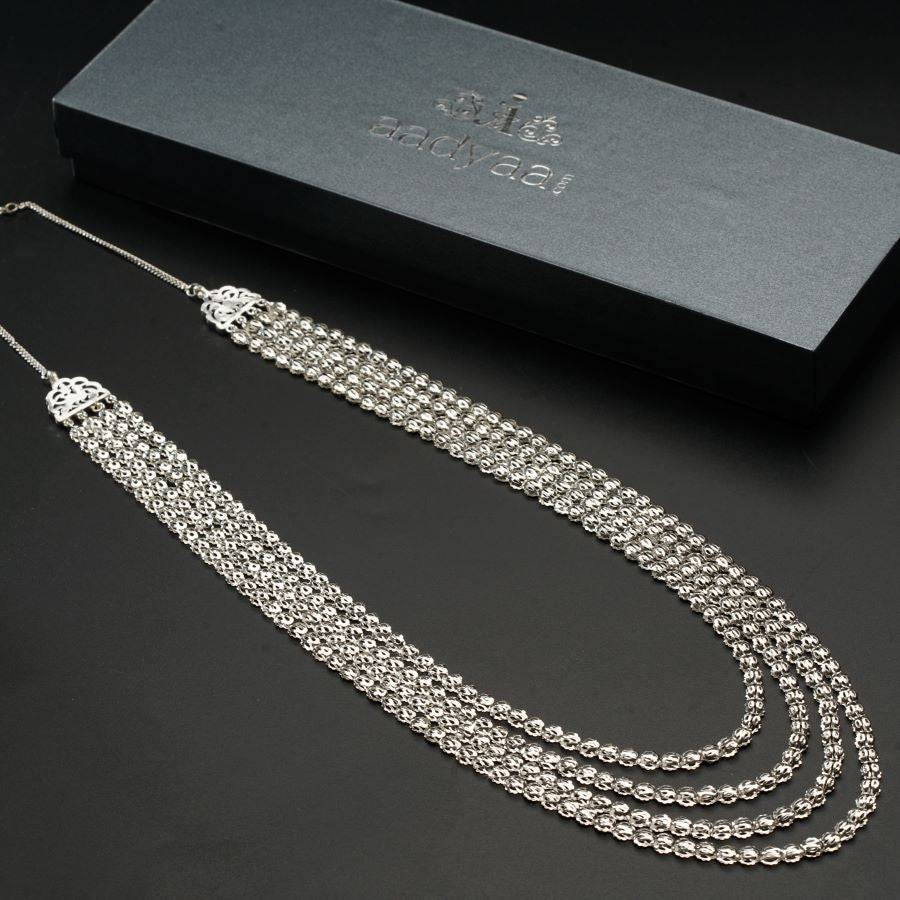 a silver necklace with a box on a table