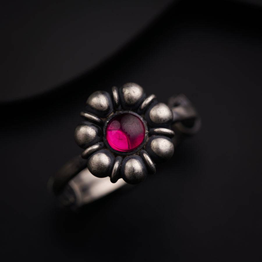 a close up of a ring with a red stone