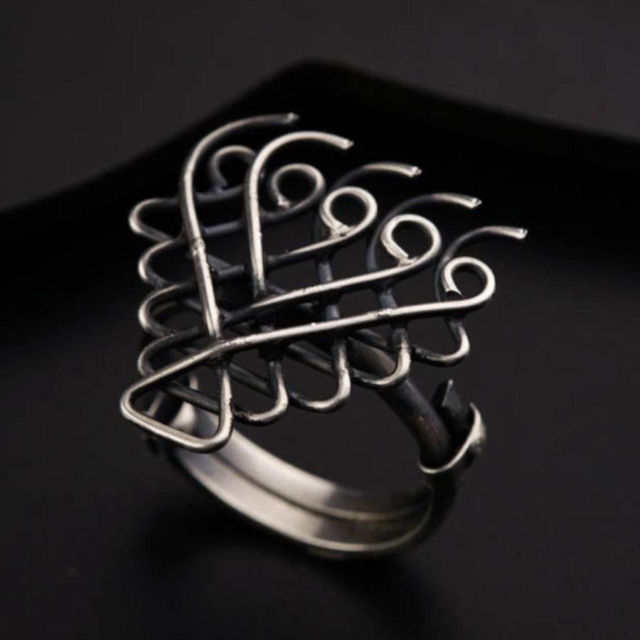 a silver ring sitting on top of a black surface
