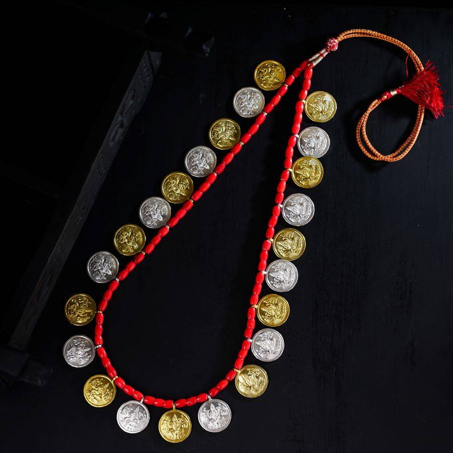 a necklace made of coins and a red string