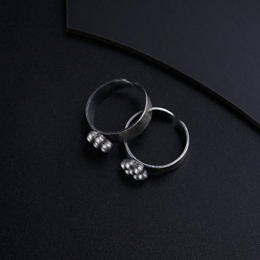 a pair of silver rings sitting on top of a black surface