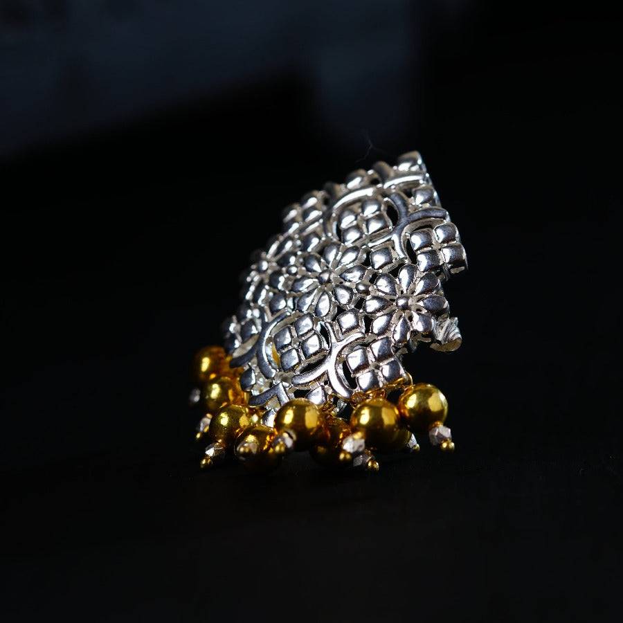 a silver and gold ring on a black surface