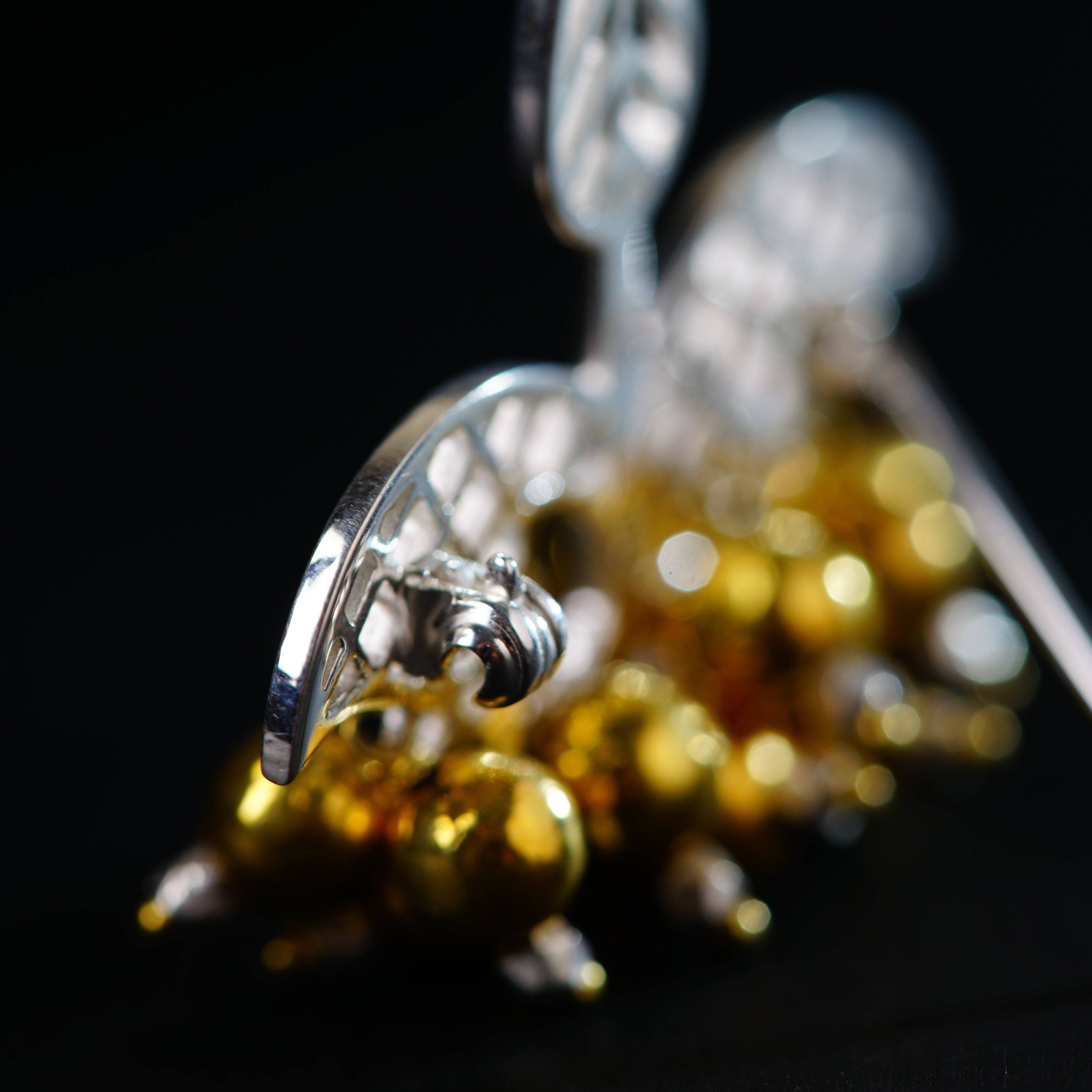 a close up of a metal object with gold balls