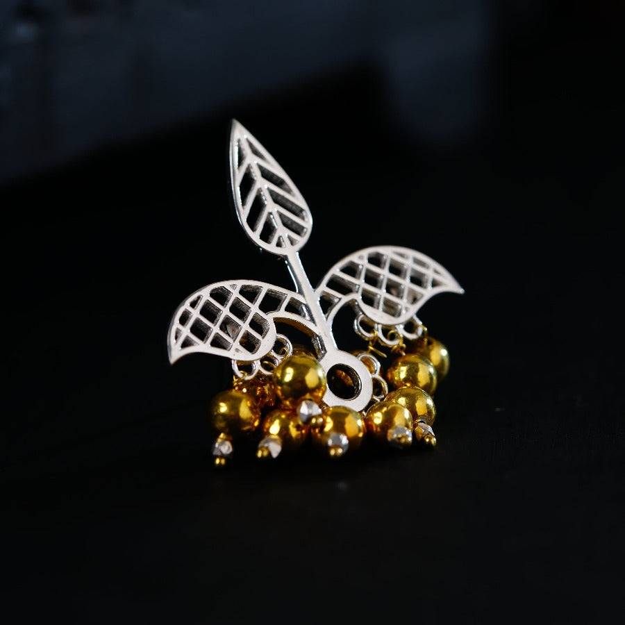 a close up of a brooch on a black surface