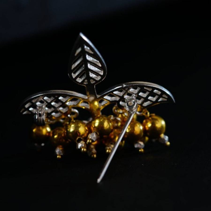 a close up of a brooch on a black surface