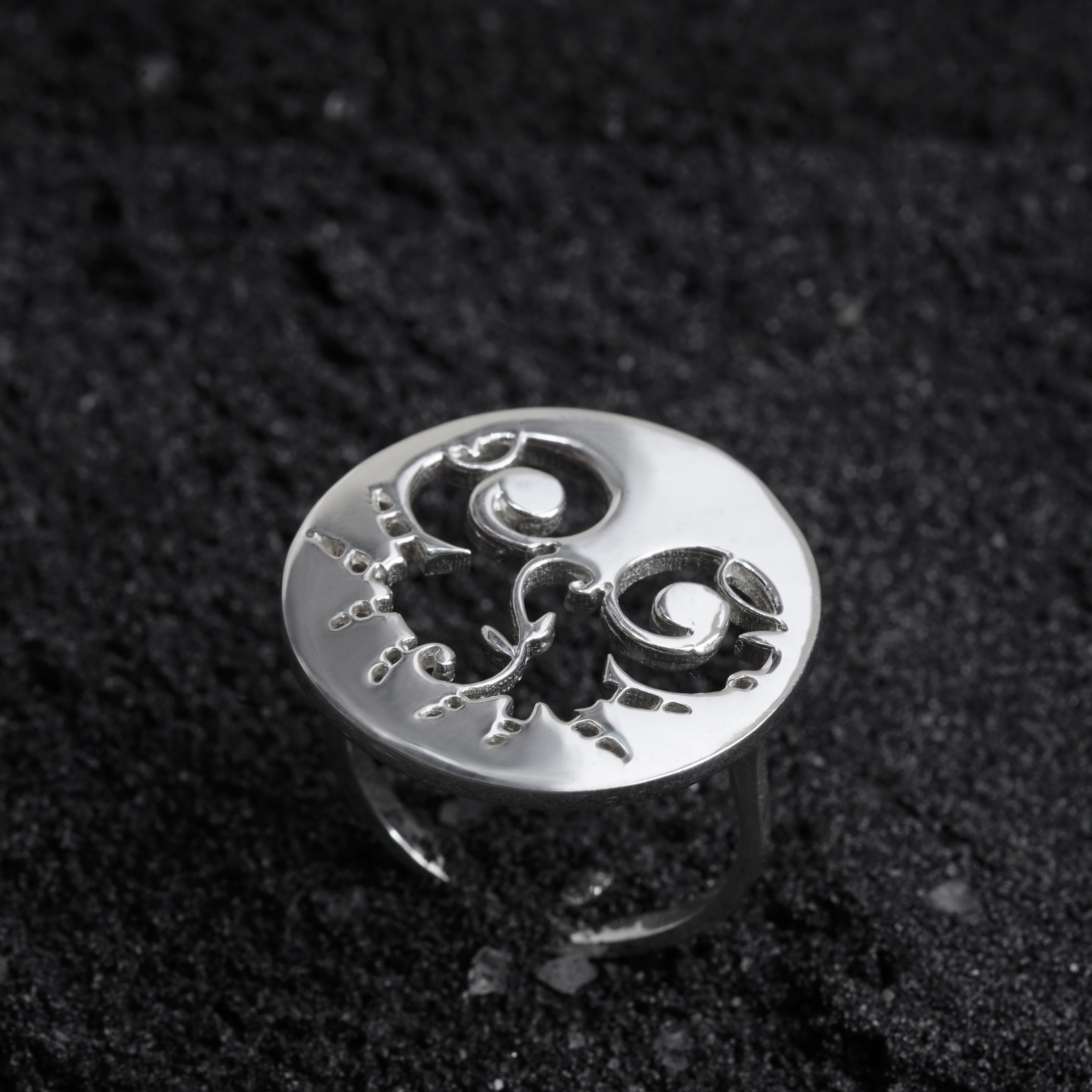 a silver ring sitting on top of a black surface