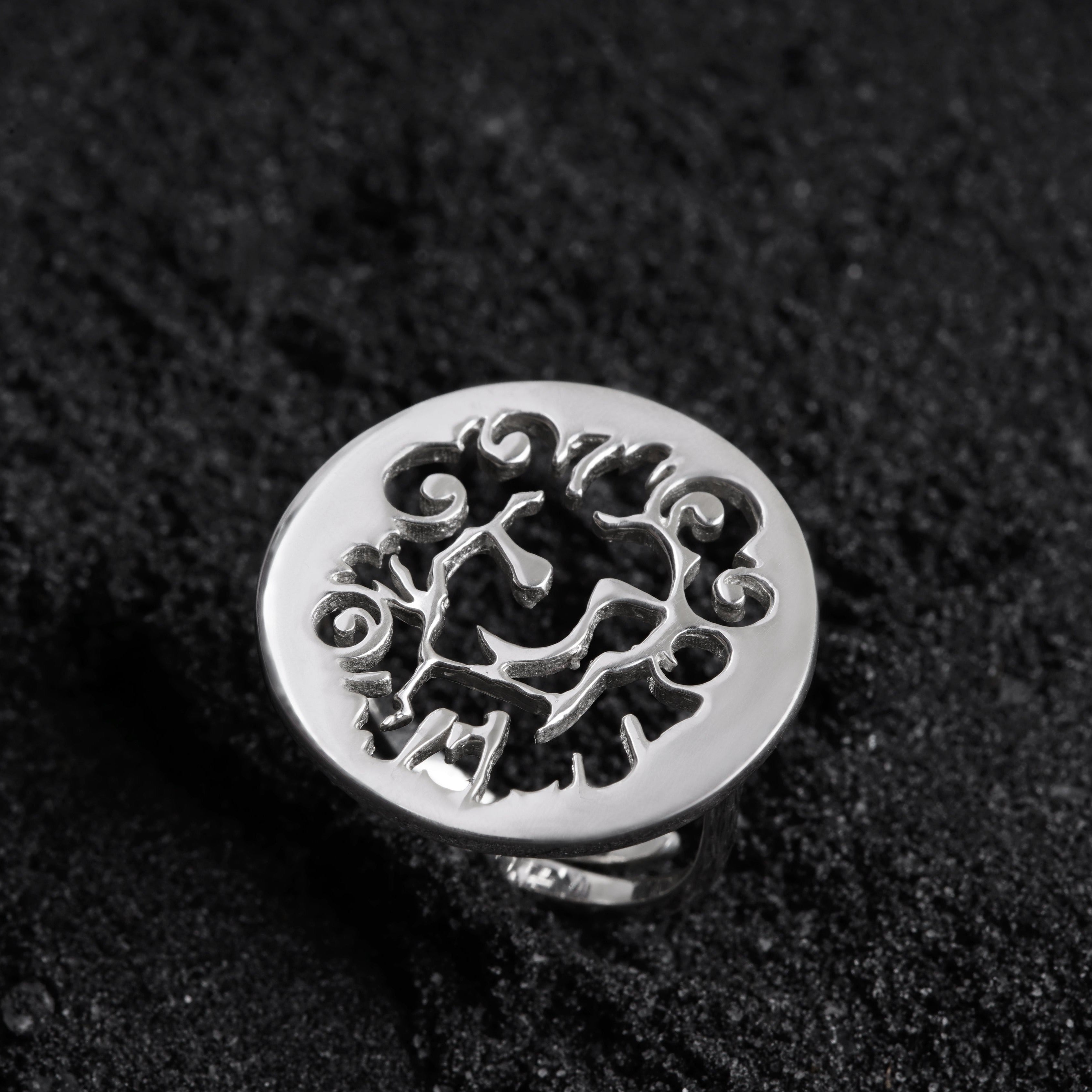 a silver ring sitting on top of a black surface