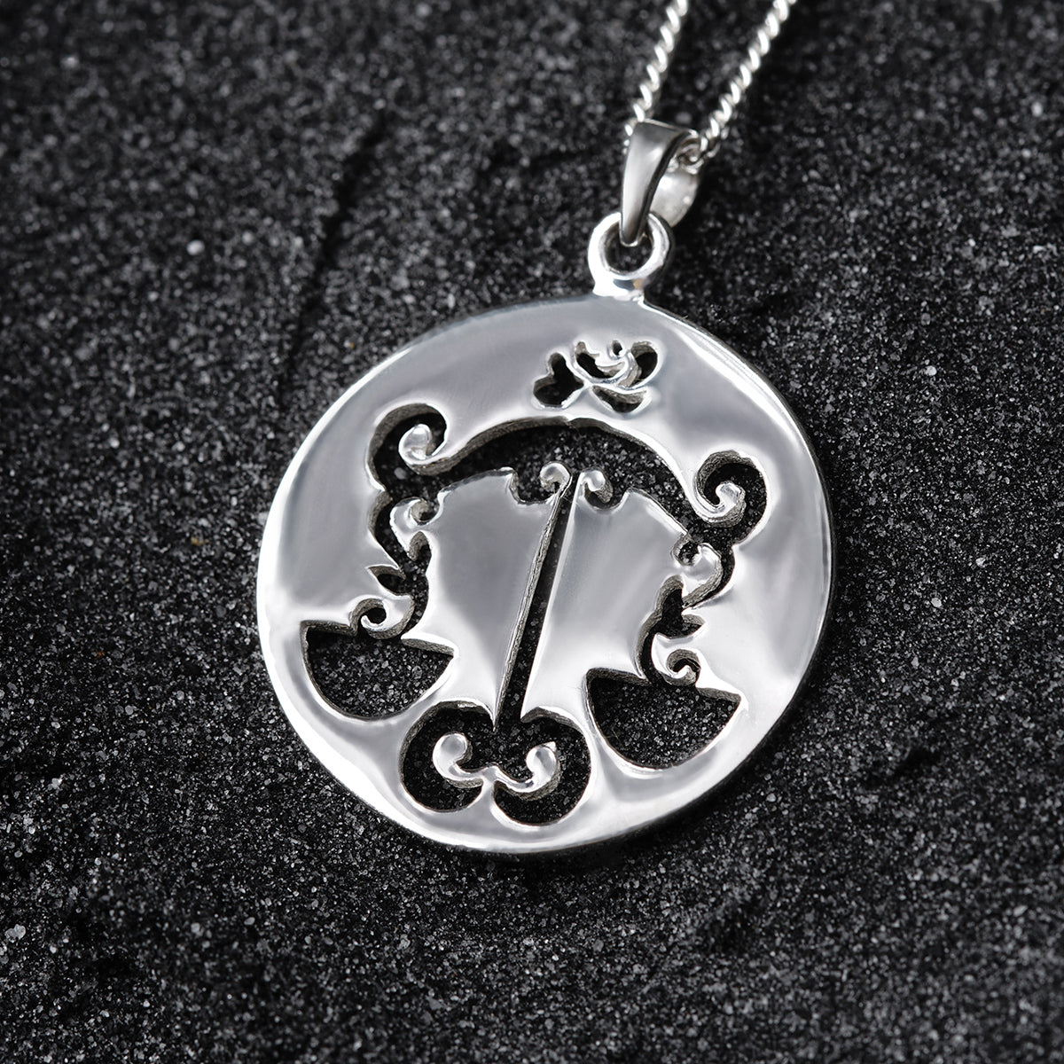 a silver pendant with a clock on it