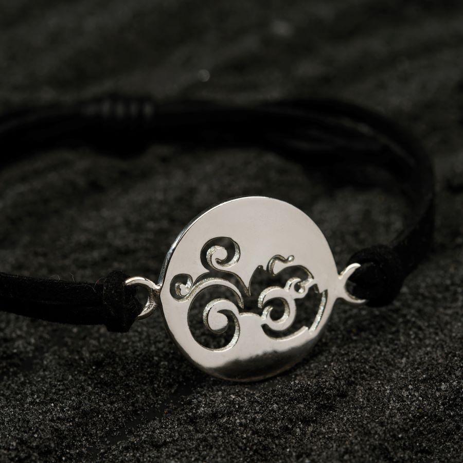 a black cord bracelet with a silver plate on it