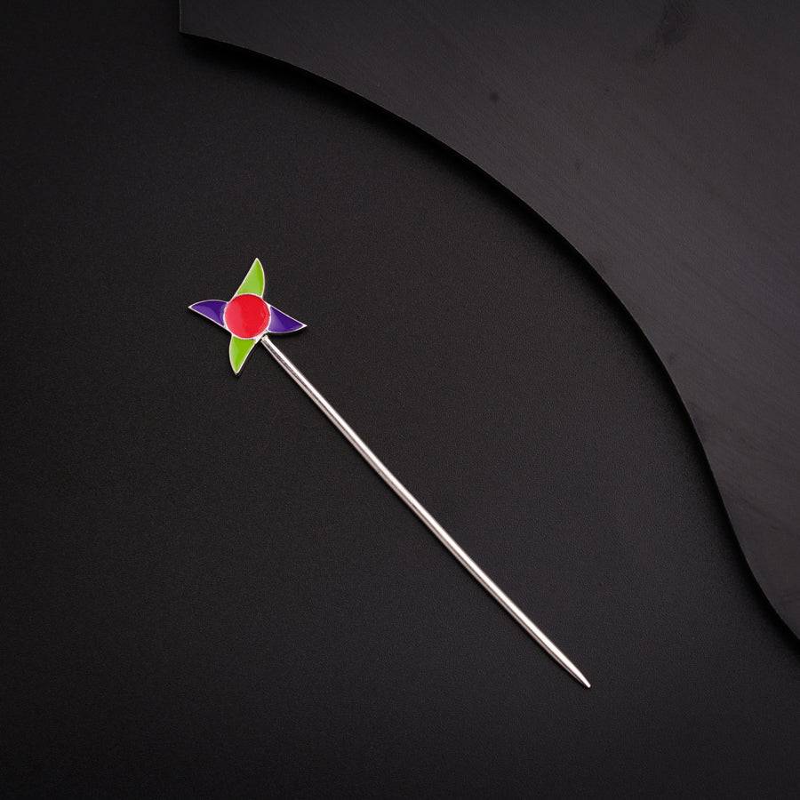 a pinwheel on a stick on a black surface