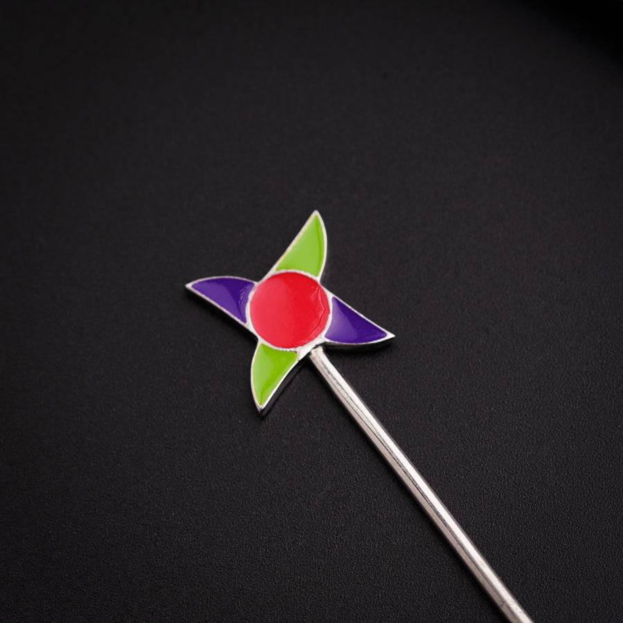 a pinwheel pin sitting on top of a black surface