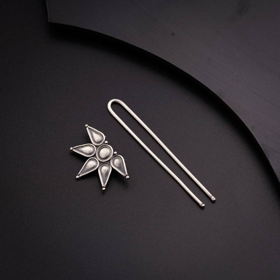 a pair of metal pins and a pin on a black surface