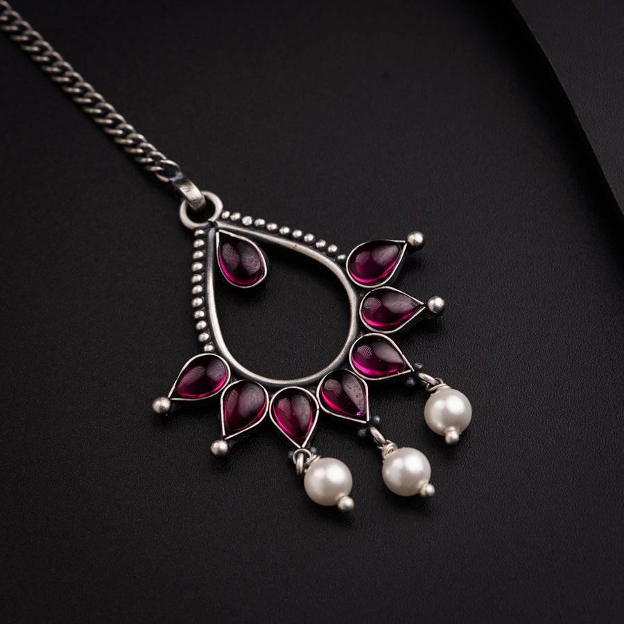 a close up of a necklace on a black surface