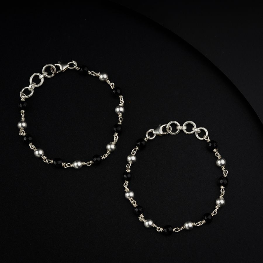 a pair of black and silver bracelets on a black surface