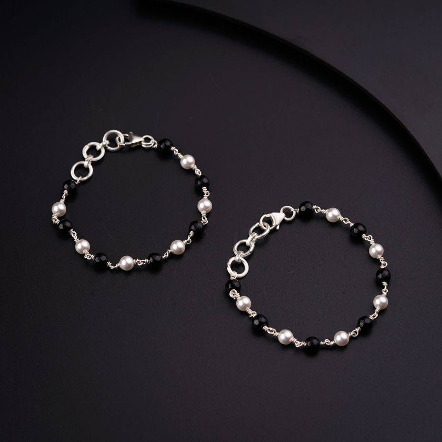 a pair of black and white bracelets on a black surface