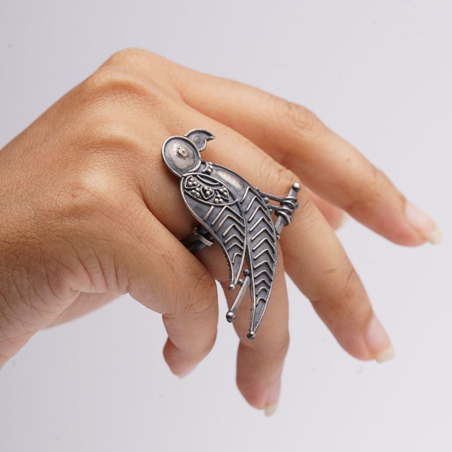 a woman's hand with a ring with a bird on it