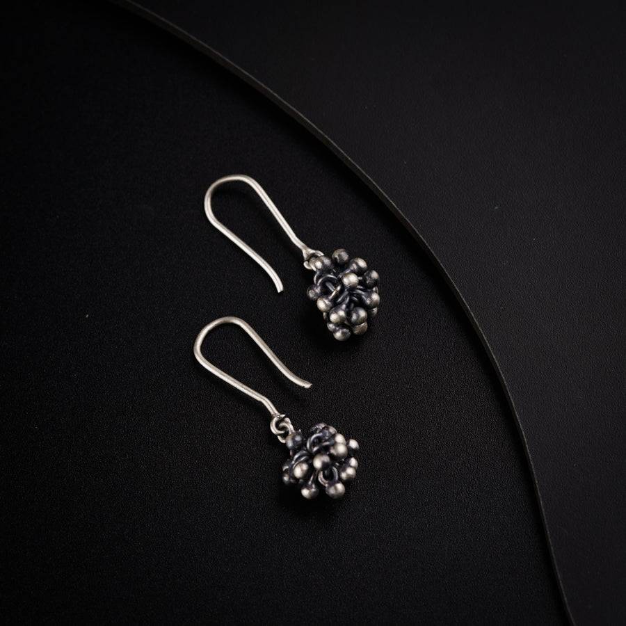 a pair of earrings sitting on top of a black surface