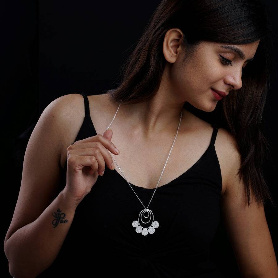 a woman wearing a black top and a silver necklace