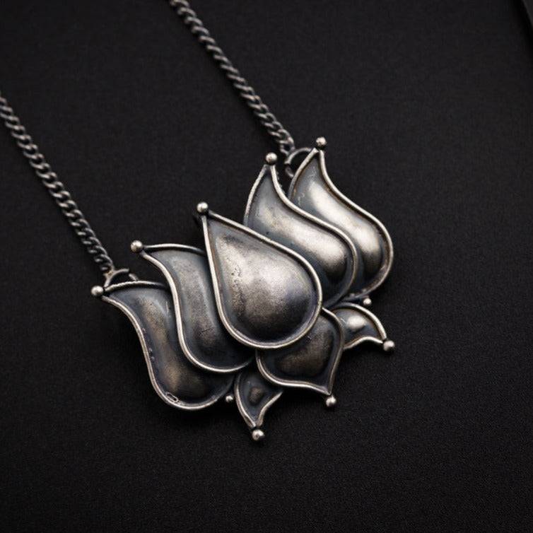 a silver necklace with a flower design on it