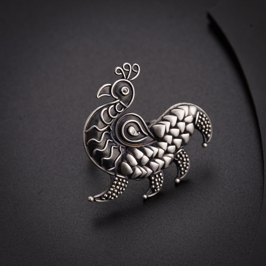 a silver brooch with a bird on it