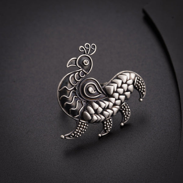 a silver brooch with a bird on it